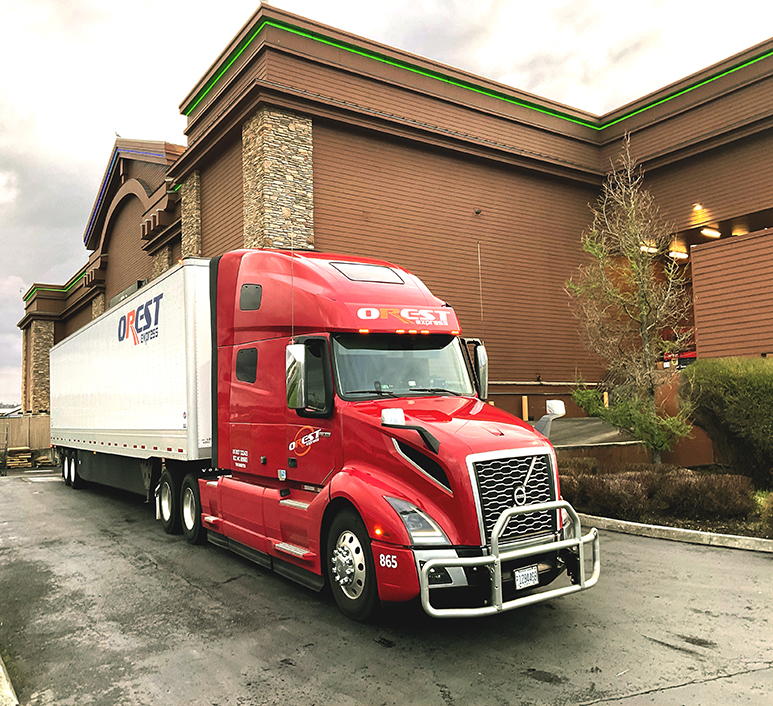 Red OREST Express truck parked near a commercial building